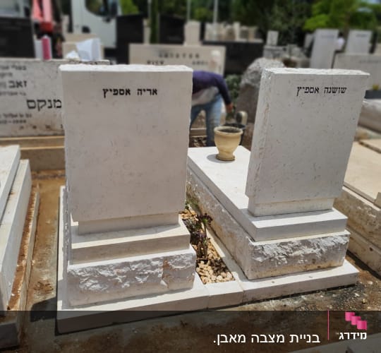 שני מצבות לבנות עם כיתוב בעברית בבית קברות